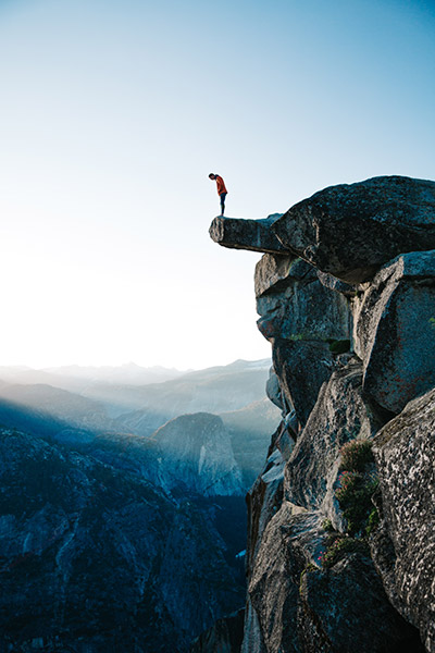 Vertical Photo of Man on a Cliff