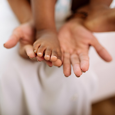 Mother's hands and child's foot