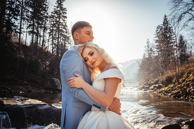 Wedding couple on a mountains and rivers background in the sunset
